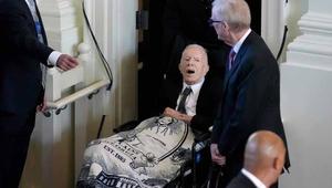 Jimmy Carter in a wheel chair at his wife's funeral